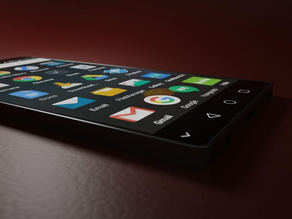 Close-up of a smartphone displaying various app icons in a low-light setting.
